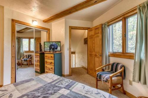 een slaapkamer met een bed, een ladekast en een spiegel bij Woods Child Cabin By Beyond Expectation W Hot Tub in Gatlinburg