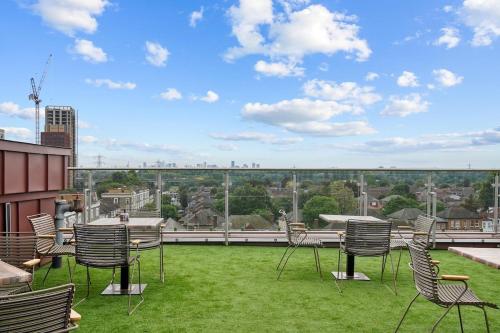 a balcony with chairs and a view of a city at Modern Studio with Balcony Godino Hotel Ilford in Ilford
