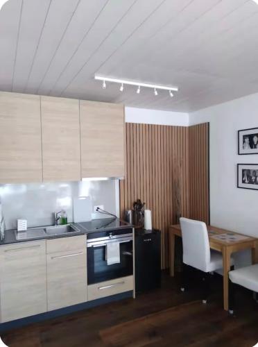 a kitchen with a stove and a table with a chair at Boutique Penthouse Terrace Apartment in JuraParc in Wil