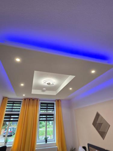 a living room with a blue ceiling and a window at Stilvoll zu Hause mit Charme, bis zu 7 Personen in Halberstadt