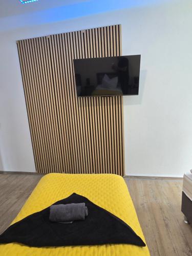 a bedroom with a yellow bed with a tv on the wall at Stilvoll zu Hause mit Charme, bis zu 7 Personen in Halberstadt
