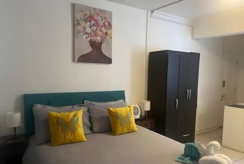 a bedroom with a bed with yellow pillows at Eco Dpto Estudio El golf 9 in Santiago