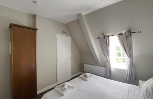 a bedroom with two beds and a window at Château Baffy in Colombiers-sur-Seulles