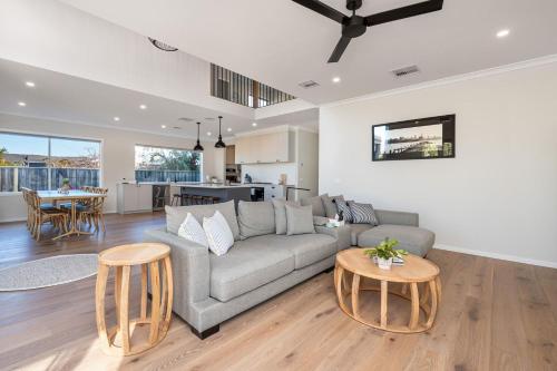 a living room with a couch and a table at Solara House with Heated Pool and Cinema Room in Safety Beach