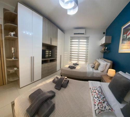 a bedroom with two beds and a blue wall at Cheerful holiday two bedrooms flat with BBQ in Msida