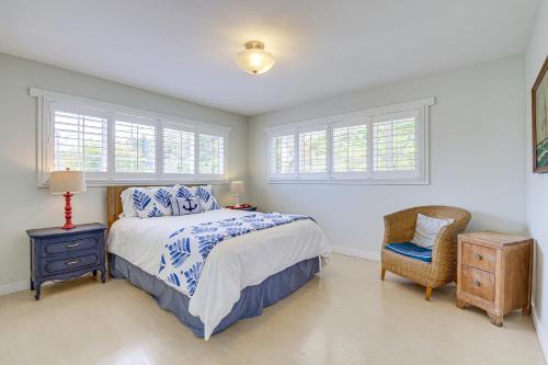 a bedroom with a bed and a chair and windows at Mtn-View Camano Island Retreat Overlooking Beach in Camano