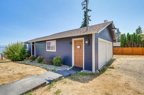 a small house with a brown door in a yard at Mtn-View Camano Island Retreat Overlooking Beach in Camano