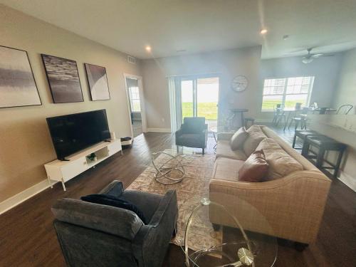 a living room with a couch and a flat screen tv at Spacious Wyoming MI Getaway- Minutes to GR in Wyoming