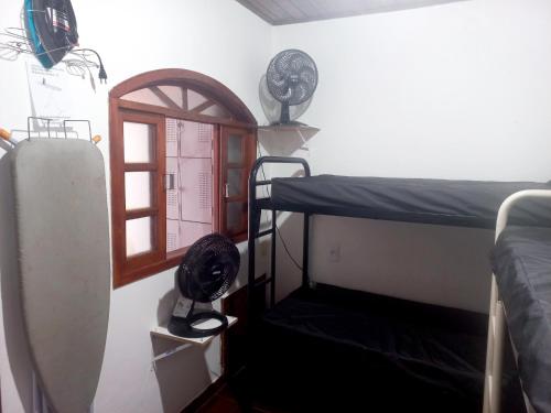 Casa Temporada no Rio de Janeiro في ريو دي جانيرو: غرفة بسريرين بطابقين ونافذة