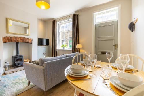 a living room with a table and a couch at World Heritage Saltaire Stylish Cottage in Saltaire