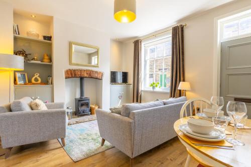a living room with two couches and a table at World Heritage Saltaire Stylish Cottage in Saltaire