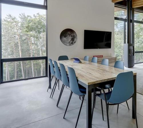 a dining room with a wooden table and blue chairs at Sterling Treehouse in Stowe