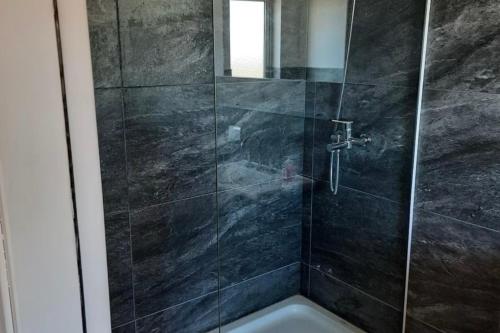 エル・カラファテにあるLuxury Villa en El Calafate, Argentinaのガラスドア付きのシャワー付きのバスルーム