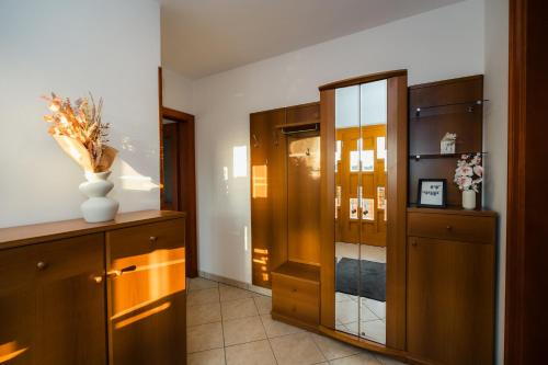a hallway with a cabinet and a vase with flowers in it at Spacious Apartment Senozece - with terrace & grill in Senožeče