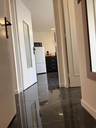 a hallway with a kitchen with a refrigerator at l hibou in Avranches