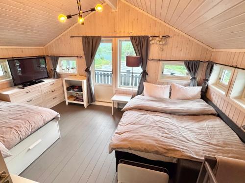 a bedroom with two beds and a television in it at Riverfront house with 98 inch TV, ps5 & activities in Narvik