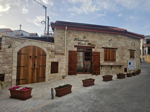 a brick building with pots of flowers in front of it at Katerinas Sweet Place studio 1 in Tsadha