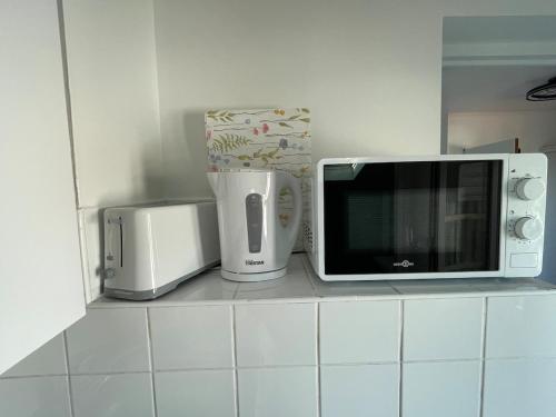 a microwave and other appliances on a kitchen counter at Studio calme et rénové -230 in Dax