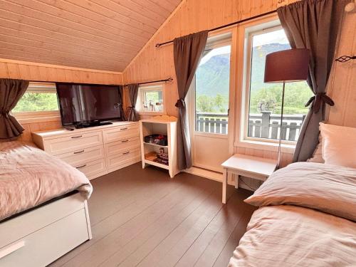 a bedroom with a bed and a tv and a window at Riverfront house with 98 inch TV, ps5 & activities in Narvik