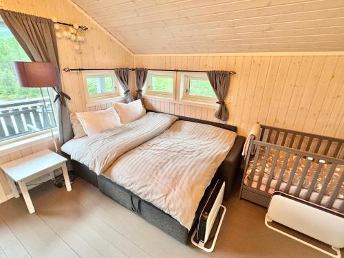 a small bedroom with a bed and a window at Riverfront house with 98 inch TV, ps5 & activities in Narvik