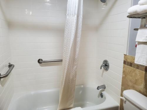 a bathroom with a tub and a toilet and a shower at River Hill Inn & Suites in Hudson