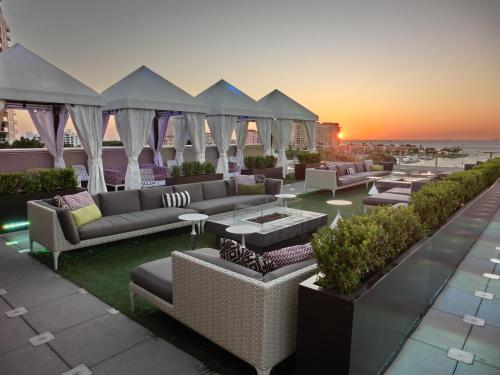a rooftop patio with couches and tables and the sunset at The Birchwood in St Petersburg