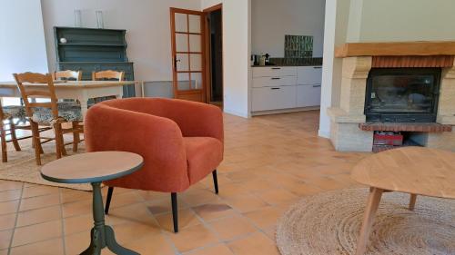 a living room with a chair and a fireplace at Maison Aksel in Beaumes-de-Venise