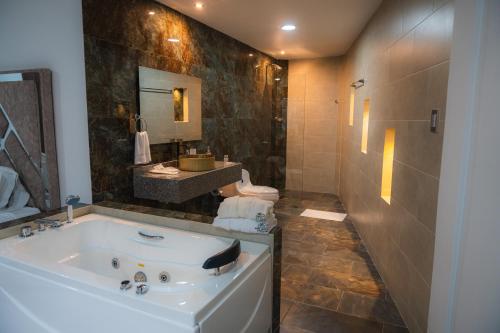 a bathroom with a tub and a shower and a sink at Hotel Boutique Campestre in Florencia