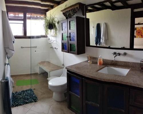 a bathroom with a toilet and a sink and a shower at Finca Chiala in Subachoque