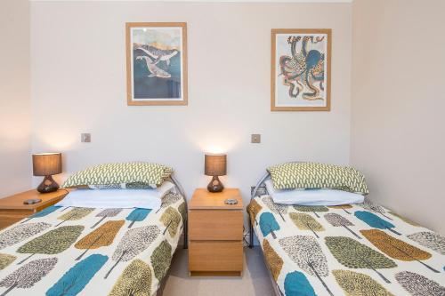 Dos camas una al lado de la otra en un dormitorio. en The Retreat, en Little Haven