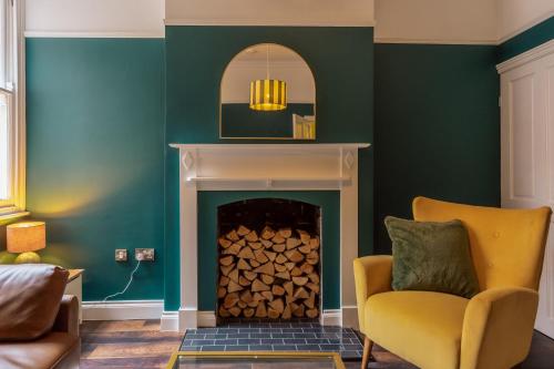a living room with a fireplace and a mirror at College Avenue Stay in Leicester