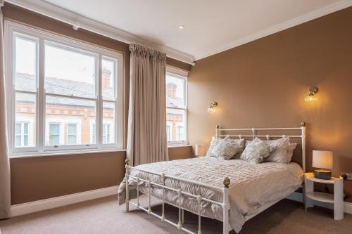 a bedroom with a bed and a large window at College Avenue Stay in Leicester