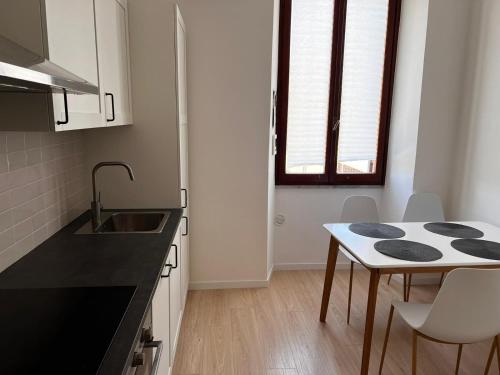 a kitchen with a sink and a table with chairs at Casa Ventuno in Civitavecchia