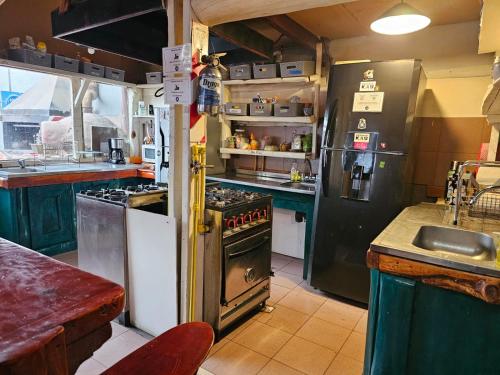 a kitchen with an old fashioned stove and refrigerator at Refugio Aku in San Carlos de Bariloche