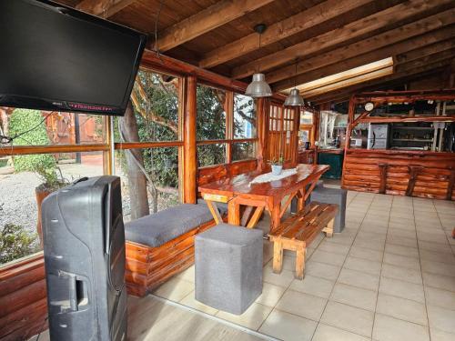 a dining room with a table and a television in a cabin at Refugio Aku in San Carlos de Bariloche