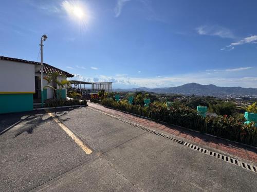 an empty street with a building and mountains in the background at Aero Glamping Hotel Pereira in Pereira