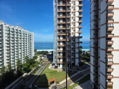 vistas a una ciudad con edificios altos y al océano en Apartamento Barra da Tijuca Frente Mar, en Río de Janeiro