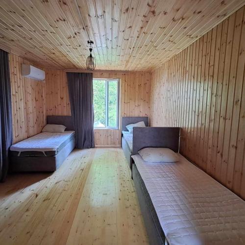 an empty room with two beds and a window at Villa Lematue in Jvari