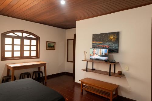 Casa Temporada no Rio de Janeiro في ريو دي جانيرو: غرفة نوم بها سرير ومكتب ونافذة