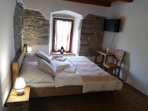 a bedroom with a large bed in a room with a window at Penzion Toliar in Vrbov