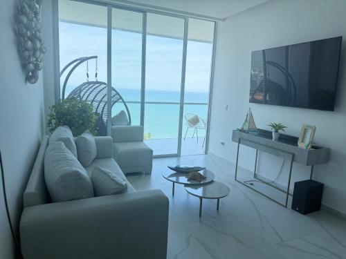 ein Wohnzimmer mit Couch und Blick aufs Meer in der Unterkunft Apto de Ensueño Frente al Mar in Playa Bello Horizonte
