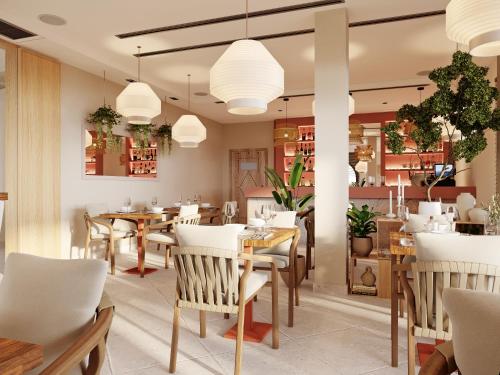 a restaurant with tables and chairs and pendant lights at Adiya Signature Hotel - Adults only in Kotor