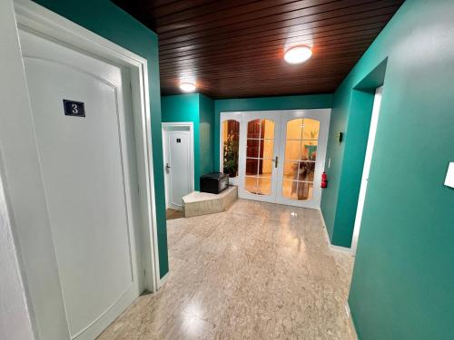an empty hallway with green walls and white doors at Modern Studio Nr 10 private Kitchenette and Bathroom in Limassol