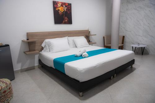 a bedroom with a bed with a teddy bear on it at Hotel Boutique Campestre in Florencia