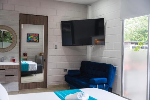 a living room with a blue chair and a flat screen tv at Hotel Boutique Campestre in Florencia