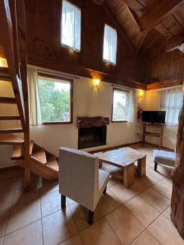 a living room with a table and a piano at Hermosa cabaña a orillas del rio in Junín de los Andes