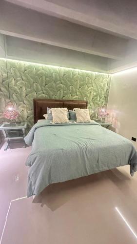 een slaapkamer met een groot bed met een groene muur bij estudio de lujo 1709 in Cartagena
