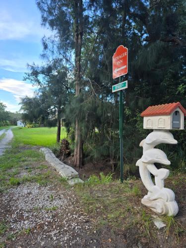 a sign with a sculpture of a snail next to a road at Voyager Inn in Merritt Island