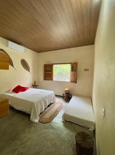 a bedroom with two beds and a wooden ceiling at Casa do sossego in Jijoca de Jericoacoara