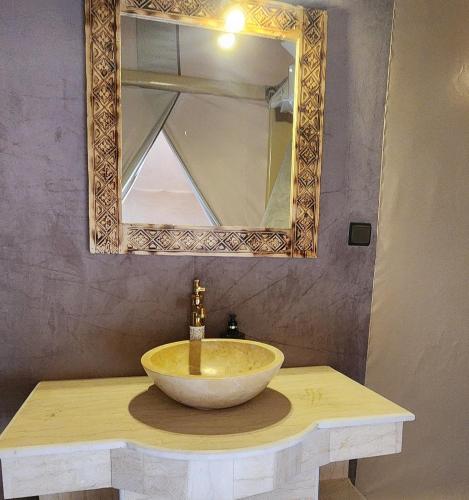 a bathroom with a bowl sink and a mirror at Sahara dream luxury in Merzouga